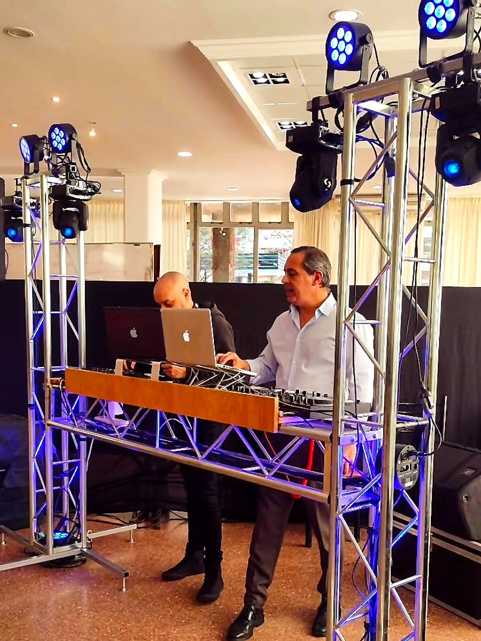 Armado de cabina de DJ con torres de truss, luces y parlantes antes del evento