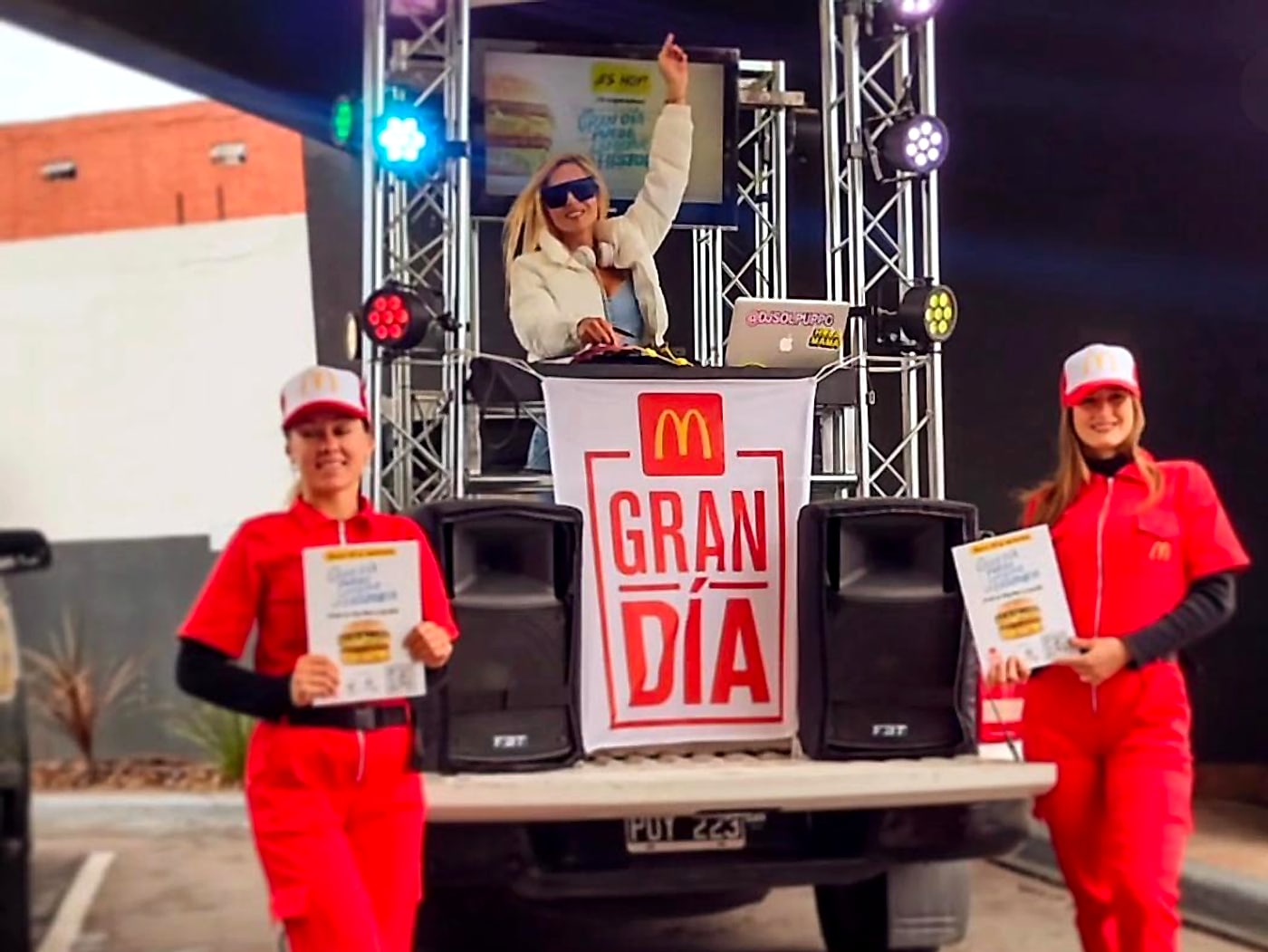 DJ sobre un escenario móvil con truss, luces y parlantes en la activación Gran Día de McDonald's